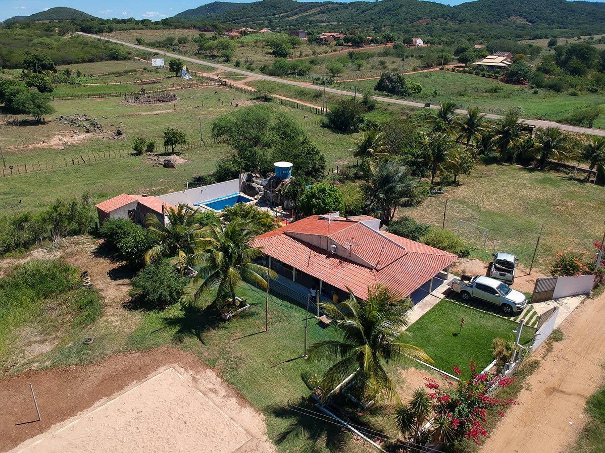 Vista aérea da Chácara Bougainville, com piscina, casa e quadra de areia